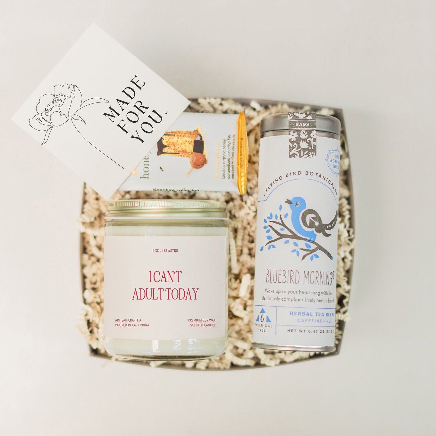 a gift box containing a jar of honey, a card, and a jar of